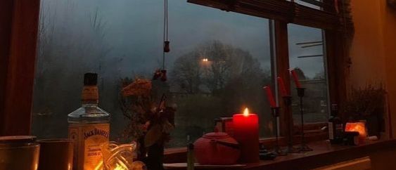 candles are lit in front of a window on a rainy day with the view outside