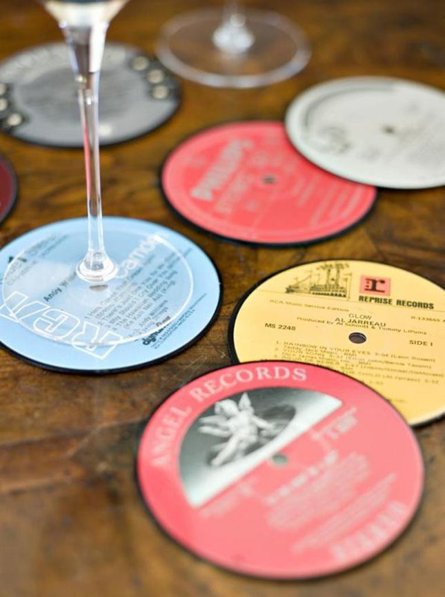 several different colored discs on a table with a wine glass in the middle and various records around them