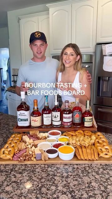 a man and woman standing in front of a table full of food