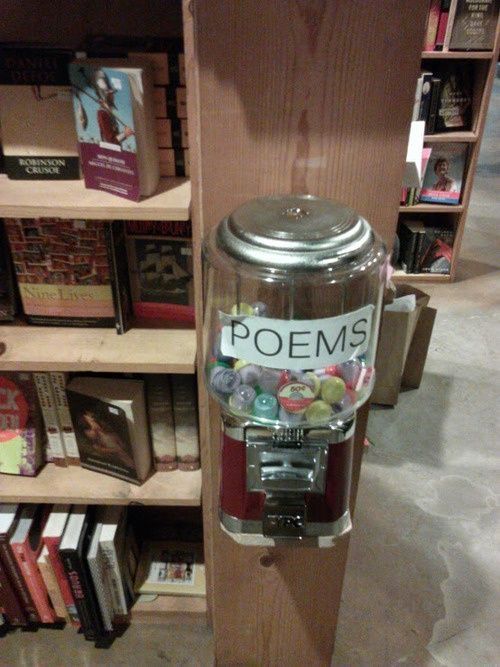 a glass jar filled with lots of candy sitting on top of a wooden shelf next to books