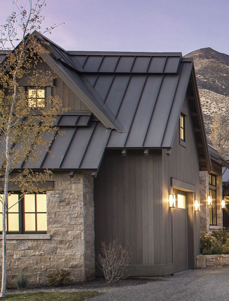 a house that has a lot of windows on the side of it with mountains in the background