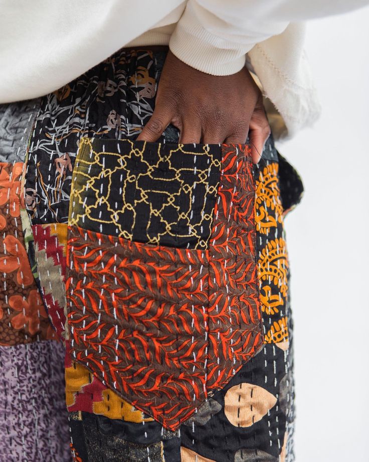 a close up of a person's pants with different patterns on them and their hands in the pocket