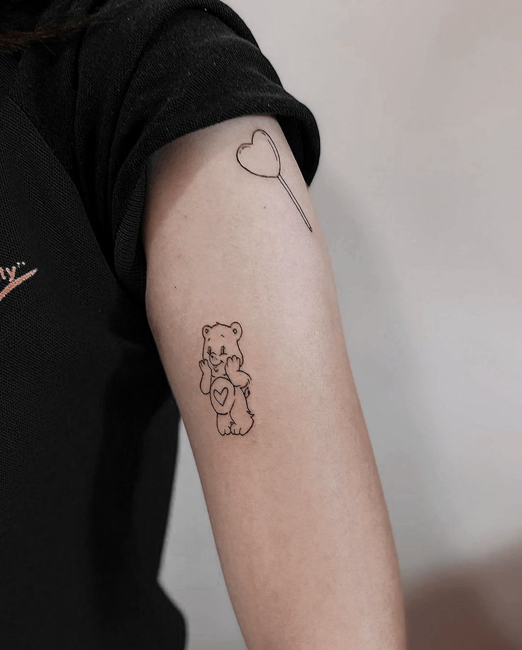 a woman with a tattoo on her arm holding a teddy bear and heart shaped balloon