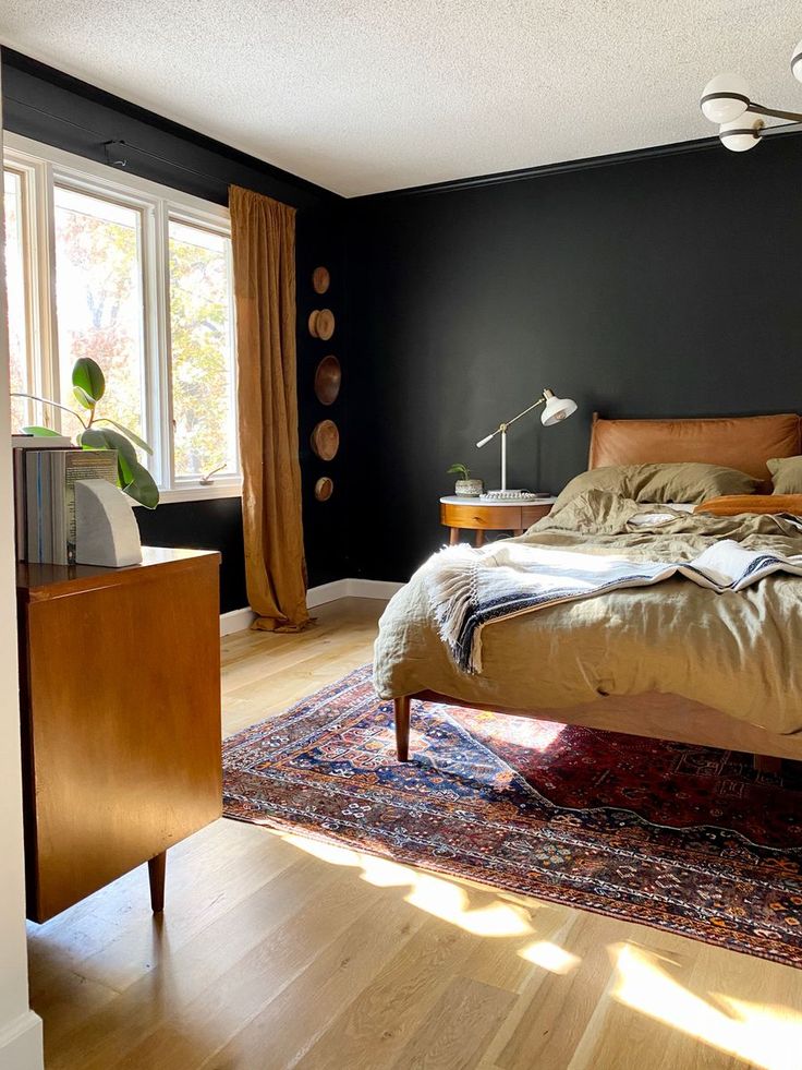 a large bed sitting on top of a hard wood floor next to a wooden dresser