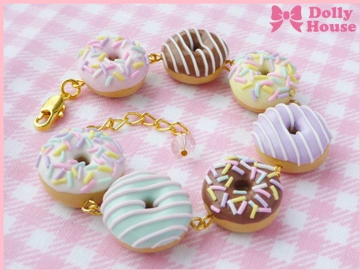 a bracelet with doughnuts and sprinkles is shown on a pink checkered tablecloth