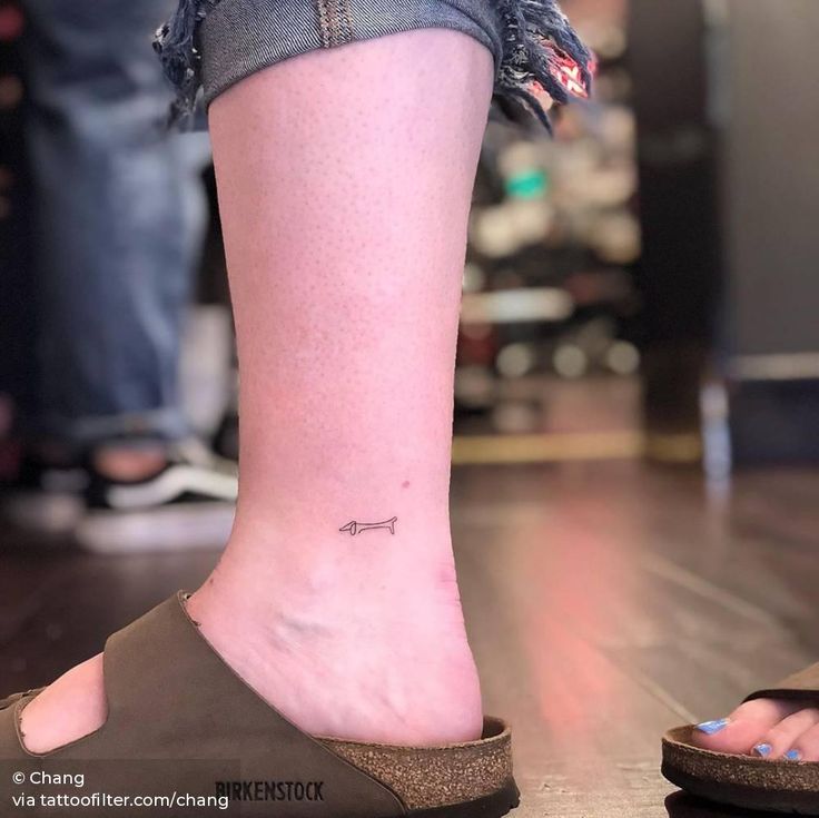 a woman's foot with a small tattoo on the lower part of her leg