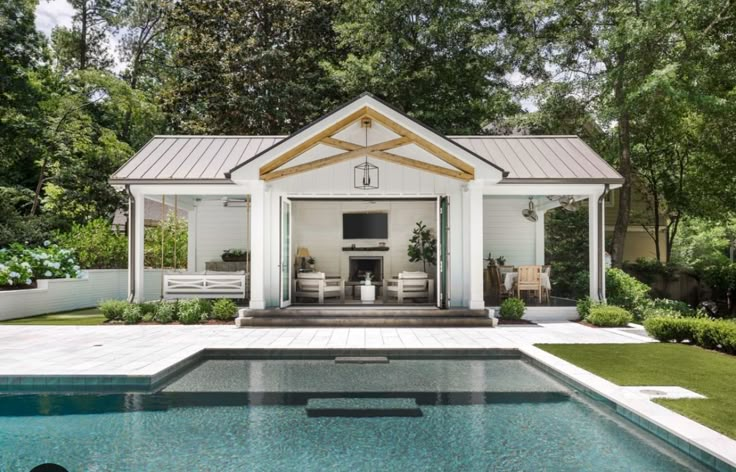 a pool with a gazebo in the middle of it next to a swimming pool