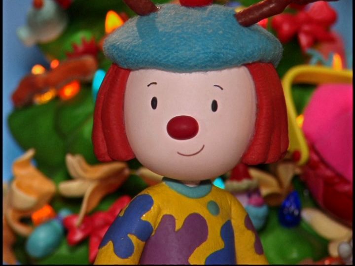 a close up of a toy figure near a christmas tree