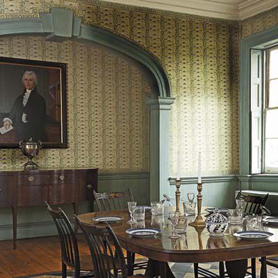 a dining room with a table and chairs in front of a painting on the wall