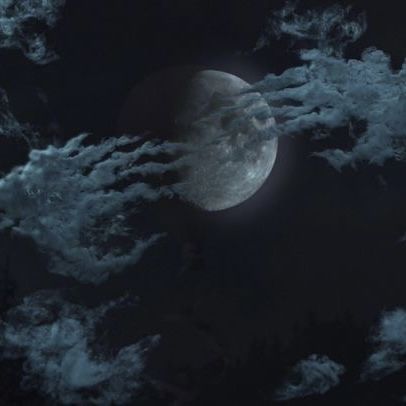 the moon is shining brightly in the dark night sky with clouds and trees around it