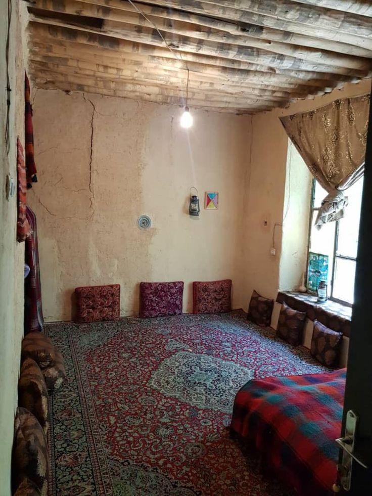 a room with many chairs and rugs on the floor