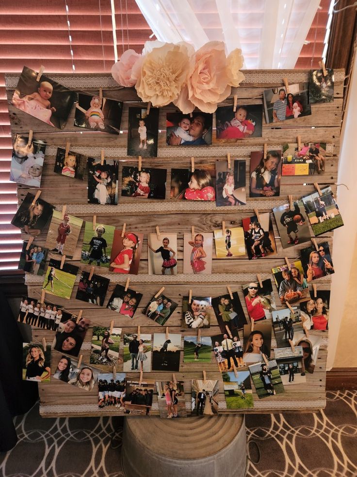 a wooden rack with pictures and flowers on it, hanging from the ceiling in front of a window