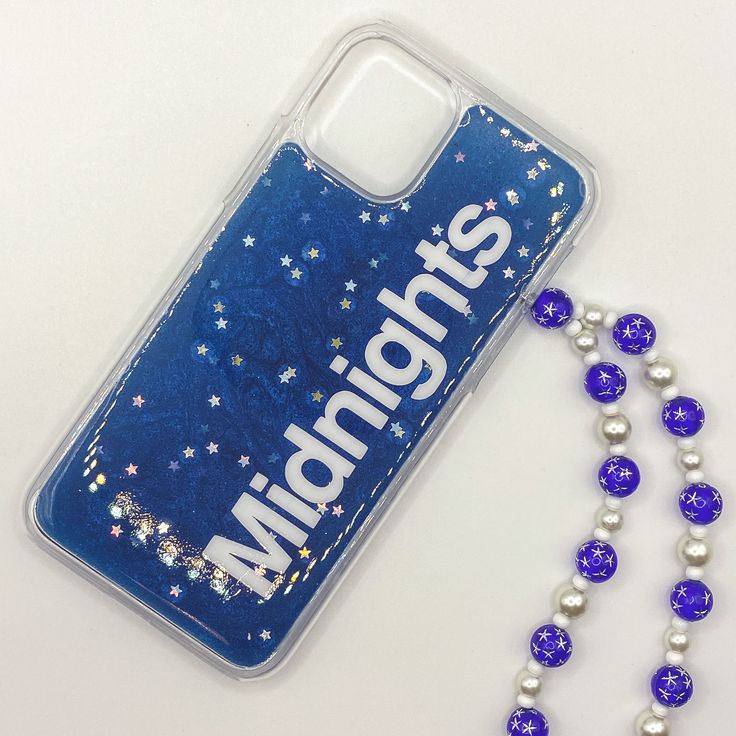 a cell phone case with beads and a lanyard attached to it on a white surface