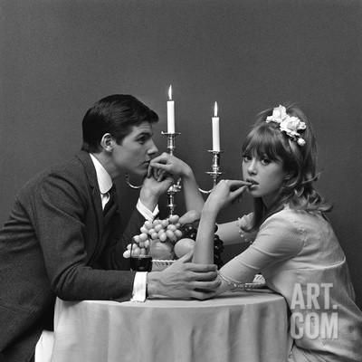 a man and woman sitting at a table with candles