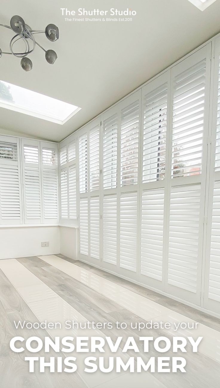 an empty room with white shutters on the windows and wood flooring in it