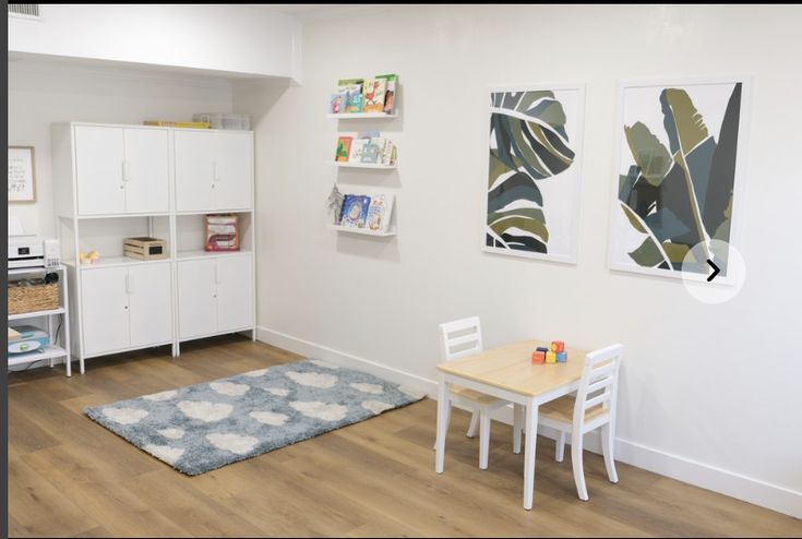 a small child's playroom with white furniture and wooden flooring is shown