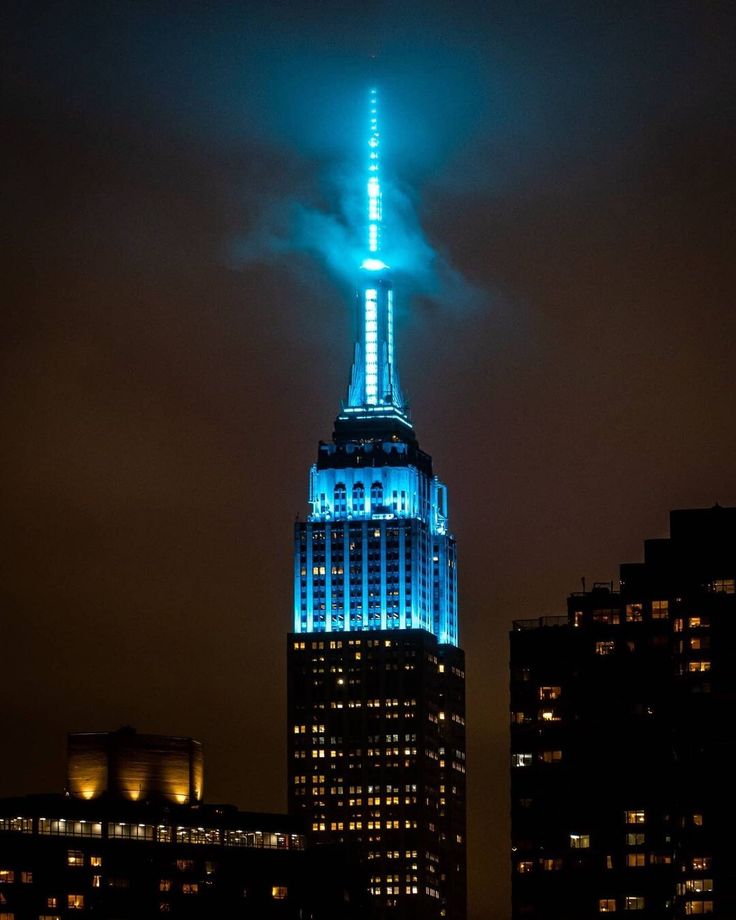 the empire building lit up in blue and white