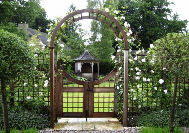 an image of a garden gate with white flowers in the center and trees around it