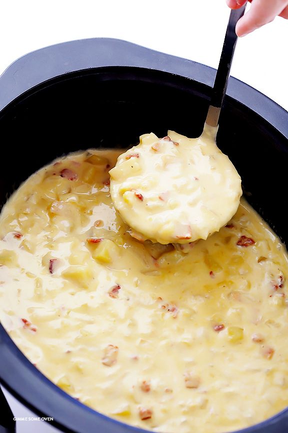 a ladle scooping some food out of a slow cooker to be cooked