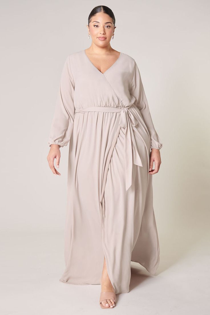 Warm and inviting, the Wholehearted Maxi Dress is a perfect combination of modest and sultry. Long balloon sleeves frame a surplice neckline separated by a tie at the waist, creating a forgiving faux wrap. The skirt maintains an airy and flowy shape that trails behind as you walk down the aisle. - Chiffon- Faux wrap- Keyhole- Elastic waist- Comes in 14 ColorsSize + Fit - Model is 5'9" and wearing size 2X- Measurements taken from size 2X - Chest: 36 1/2"- Length: 66" Fabric Self: 100% PolyesterLi Flowy Belted Wrap Dress With Surplice Neckline, Faux Wrap V-neck Dress For Fall, Flowy Wrap Dress For Date Night, Flowy Faux Wrap Maxi Dress, Flowy Faux Wrap Dress With Surplice Neckline, Flowy Wrap Dress With Tie Waist, Fall Wrap Dress With Tie Waist And Surplice Neckline, Fall Wrap Dress With Surplice Neckline And Tie Waist, Flowy Wrap Dress With Faux Wrap And Surplice Neckline