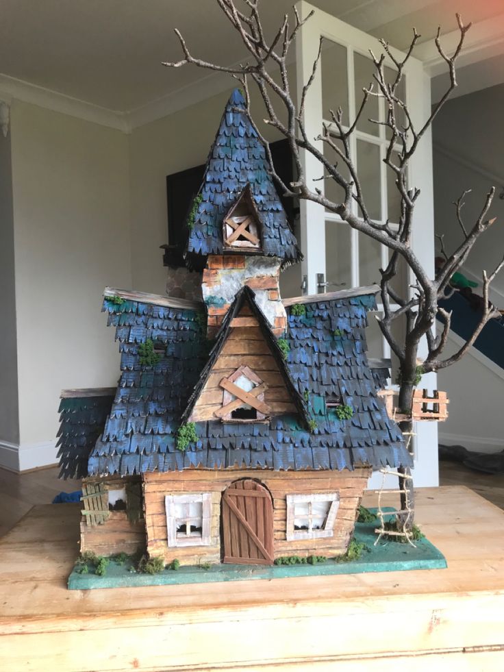 a house made out of clay with a tree in front of it