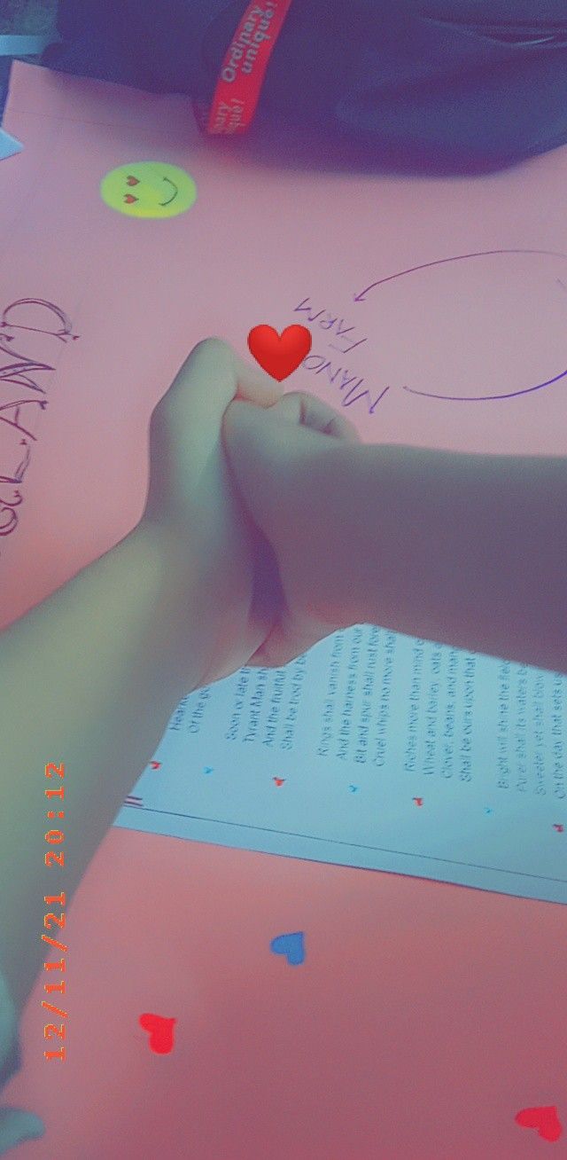 two hands holding each other over an open book with hearts on it and confetti around the edges