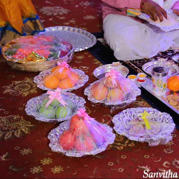 there are many small baskets on the table with food in them and one person is sitting down