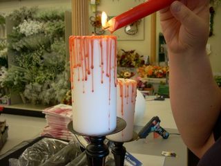 two candles with blood running down them on a table