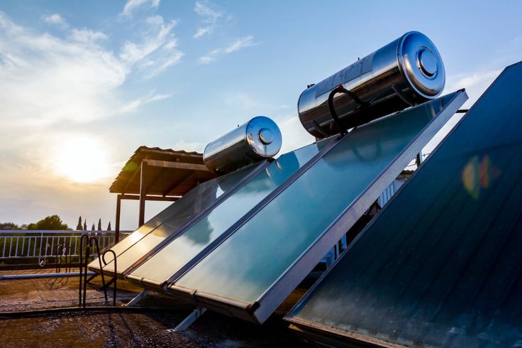 an array of solar panels on the roof of a building with sun shining in the background