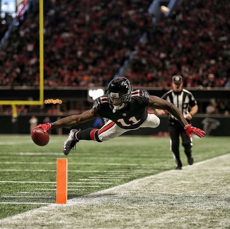 a football player diving into the air to catch a ball