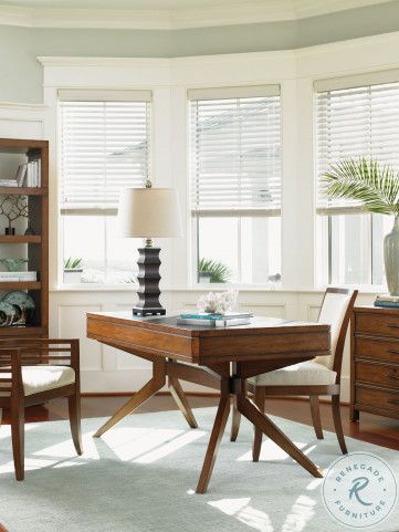 a living room filled with furniture and a lamp on top of a wooden table in front of two windows