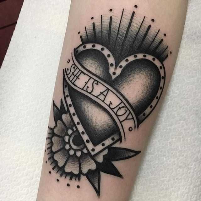 a black and white heart tattoo on the arm