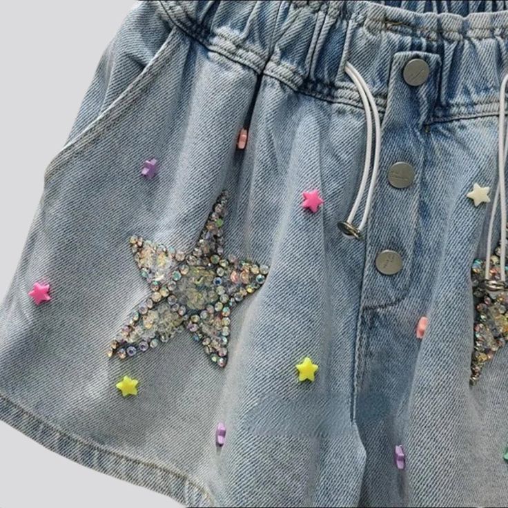 Introducing the 2023 Summer Collection the perfect balance between vintage nostalgia and trendy flair. Our Rhinestone Star Embellished Denim Shorts. Y2K Style will bring you back to the era of innocence and fun. Featuring a high-waist. baggy fit. rhinestone stars. buttons. and rubber closure. these shorts will make you feel like you've stepped into a time machine!Why These Shorts Will Make You Feel Like a Kid Again A Blast from the Past: Step back in time with the vintage Y2K style. featuring a Trendy Star Print Jean Shorts For Spring, Trendy Summer Jean Shorts With Star Print, Trendy Jean Shorts With Star Print For Spring, Trendy Jean Shorts With Star Print For Summer, Summer Denim Shorts With Star Print, Trendy Cotton Jean Shorts With Star Print, Spring Star Print Jean Shorts, Denim Blue Summer Bottoms With Star Print, Summer Denim Blue Star Print Bottoms