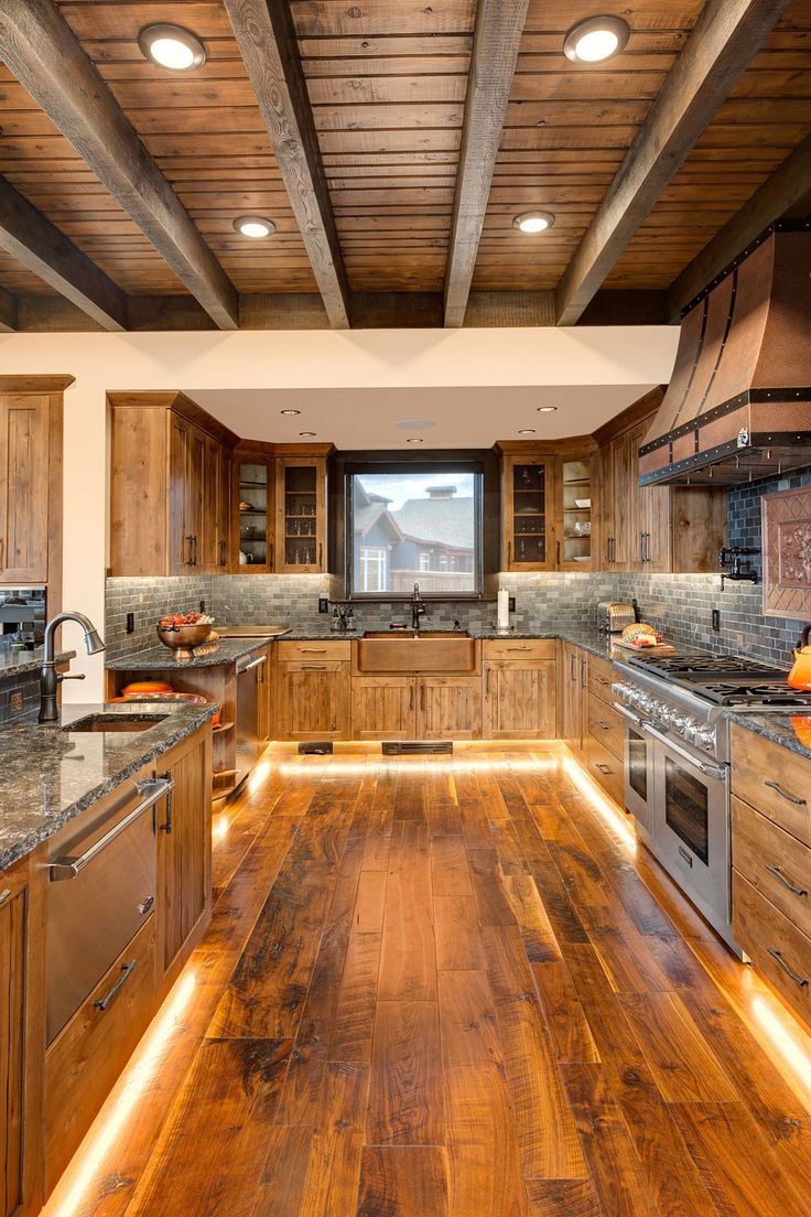 a kitchen with wood floors and wooden ceilinging is lit up by recessed lighting