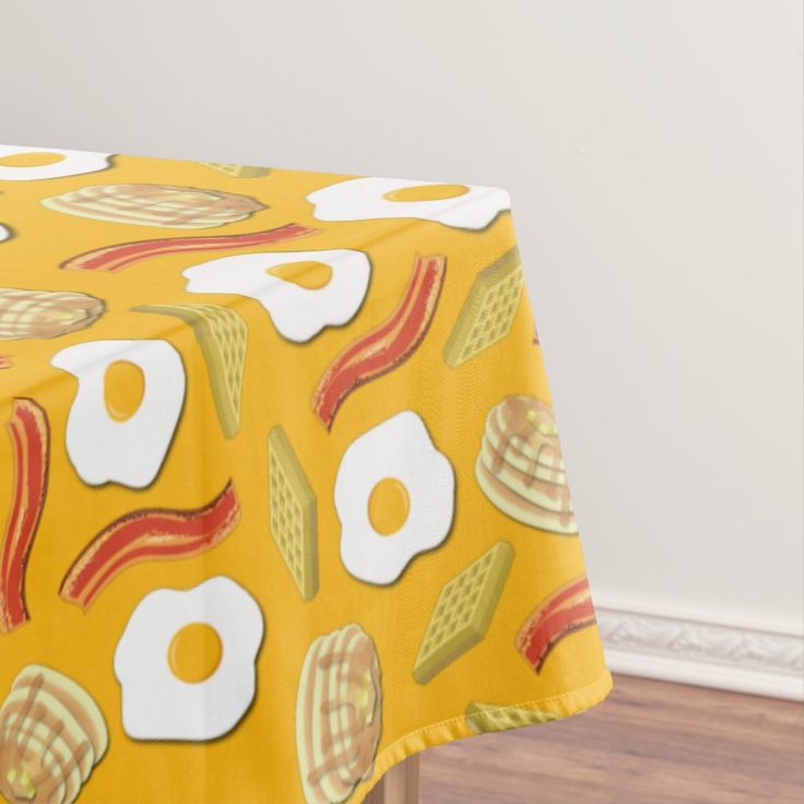 a yellow table cloth with eggs and bacon on it