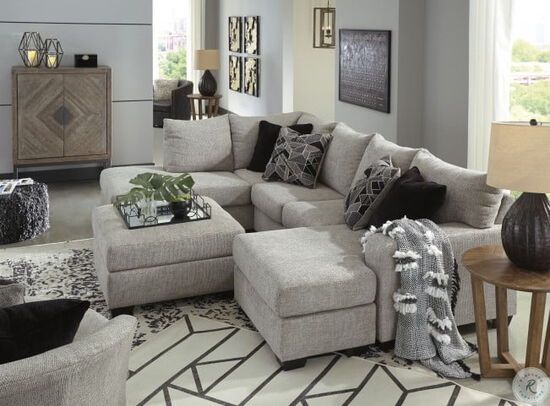 a living room with a sectional couch and coffee table in front of a large window