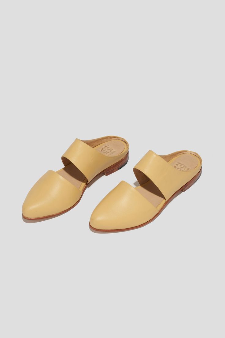 The mule is ZX’s perennial flat, inspired by traditional babouche slippers. With its sleek cut-out upper and almond shaped toe, this style makes feeling comfortable and pulled-together an easy task for days filled with lots of activity. This pair is crafted from pale yellow kidskin. Style yours with statement pants for a chic vacation look. Who it’s for: The woman with refined style who likes to go places by foot. Kidskin leather upper and undyed vegetable-tanned leather lining. Leather sole and stacked heel. Handmade in Argentina. Chic Closed Toe Mules With Rubber Sole, Spring Slip-on Mules With Leather Sole, Chic Mules With Rubber Sole And Closed Toe, Spring Slides With Rubber Sole And Slip-on Fit, Beige Slip-on Mules With Leather Footbed, Spring Leather Footbed Slip-on Clogs, Spring Leather Footbed Mules With Closed Toe, Beige Slip-on Mules With Flat Heel, Beige Flat Mules With Leather Footbed