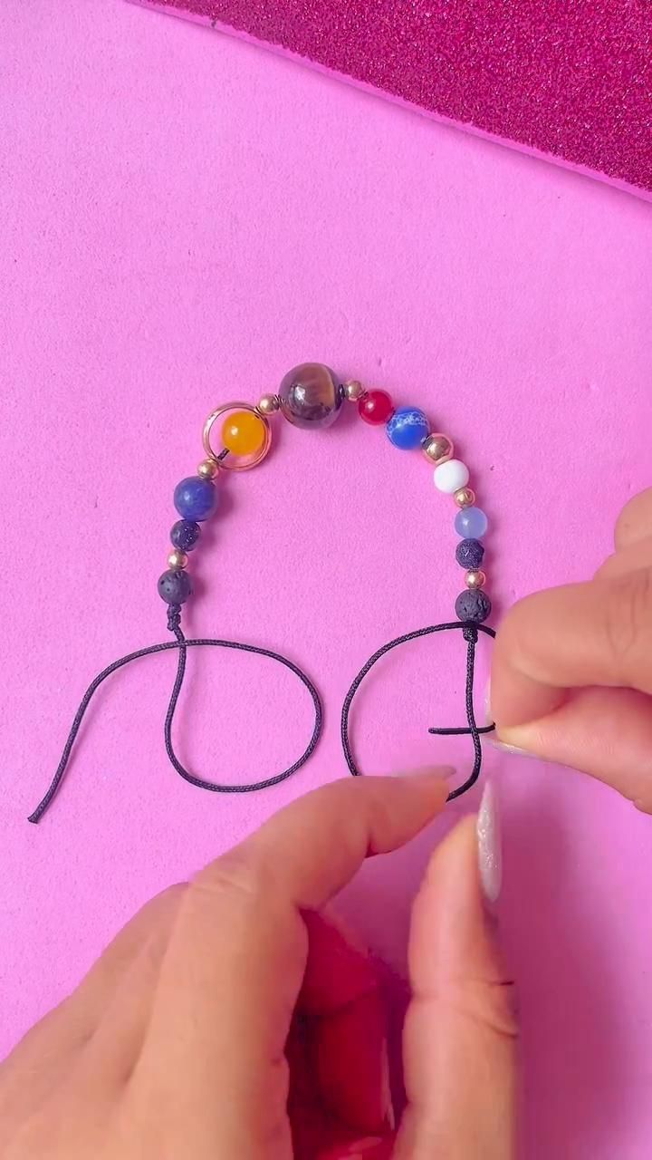 someone is making a beaded bracelet with beads