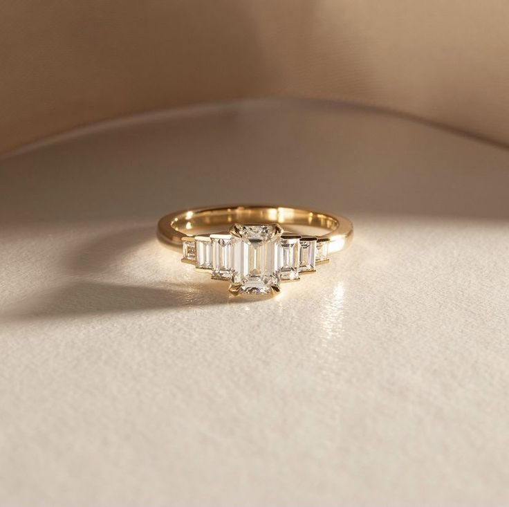 a gold ring with three baguettes on it