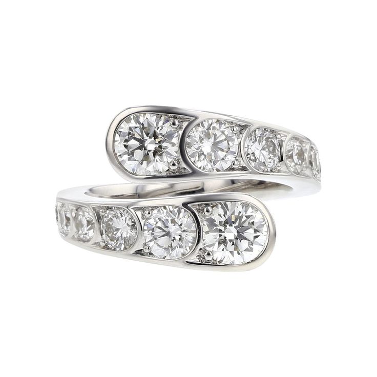 two white gold rings with diamonds on each side and one diamond set in the middle