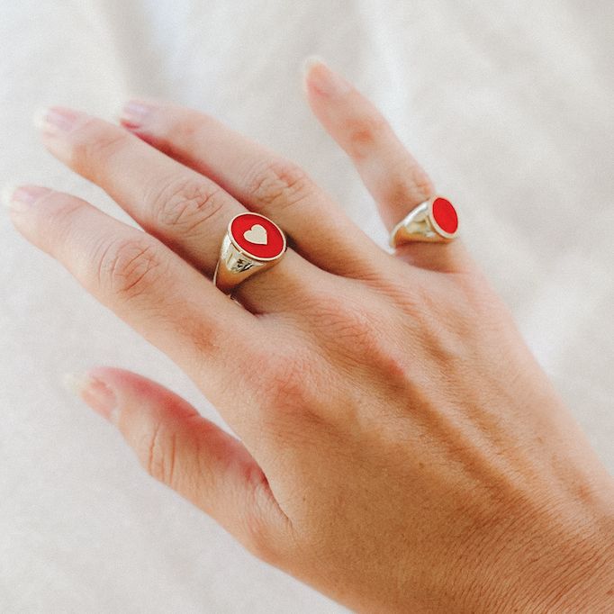 The IVY ENAMEL HEART SIGNET RING features cherry red enamel with a dainty accent heart in the center. Ring measures 14mm in height and is available in ring size 7. Please allow 5-7 business days for this style to ship. Round Enamel Ring For Valentine's Day Gift, Valentine's Day Gift Enamel Ring, Yellow Gold Enamel Ring For Valentine's Day Gift, Valentine's Day Gift: Yellow Gold Enamel Ring, Valentine's Day Gift Yellow Gold Enamel Ring, Gold Heart-shaped Enamel Rings, Red Heart Ring For Valentine's Day, Personalized Red Promise Ring, Personalized Enamel Ring For Anniversary