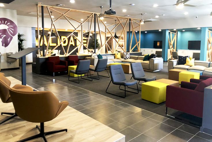 an office lobby with colorful chairs and tables