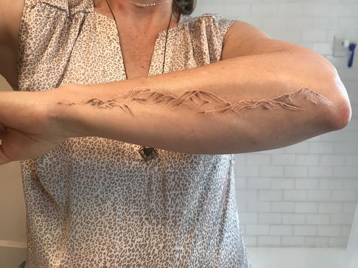 a woman is showing off her arm tattoo