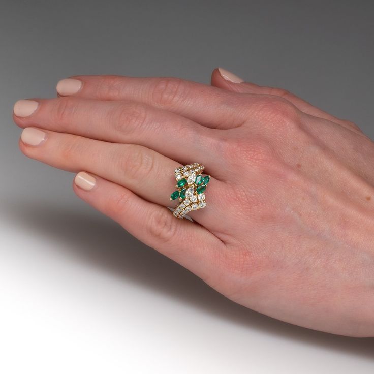 This pretty ring is centered with a cluster of two (2), prong set, marquise brilliant cut diamonds and six (6), prong set, marquise mixed cut natural emeralds. The top face of the by-pass style shank is accented with twenty-six (26), prong set, round brilliant cut diamonds. The ring measures 18.0mm at the top, rises 8.0mm above the finger, tapering to 2.9mm wide and 1.1mm thick at the base of the shank. This ring is currently a size 7. Marquise Multi-stone Diamond Wedding Ring, Heirloom Marquise Emerald Ring, Green Cluster Diamond Ring For Wedding, Emerald Cluster Ring For Wedding, Green Cluster Diamond Wedding Ring, Green Cluster Ring For Weddings, Fine Jewelry Marquise Multi-stone Cluster Ring, Marquise Multi-stone Cluster Ring Fine Jewelry, Marquise Multi-stone Cluster Ring For Formal Occasions