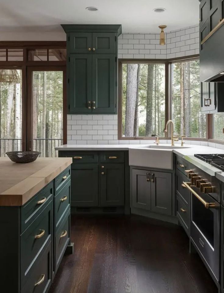 a kitchen with dark green cabinets and wood flooring is pictured in this image from the inside