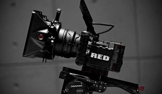 a red camera attached to a black and white photo with the words red on it