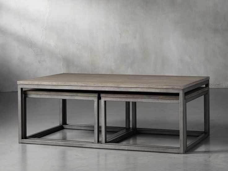 two tables sitting on top of each other in front of a gray wall and floor