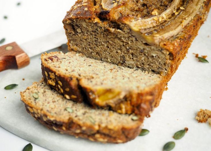 sliced loaf of banana bread sitting on top of a cutting board next to a knife