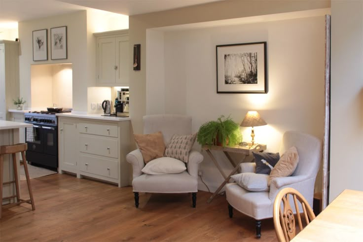 a living room filled with furniture next to a kitchen