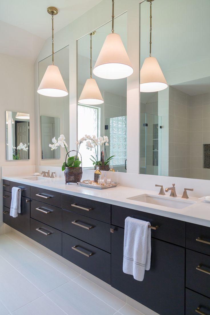 a bathroom with two sinks and three lights